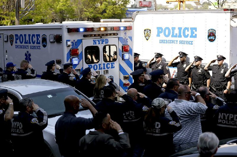 Police officers salute as the body of Brian Moore leaves Jamaica Hospital in New York, Monday, May 4, 2015. The 25-year-old police officer shot in the head over the weekend while attempting to stop a man suspected of carrying a handgun has died from his injuries, the third New York Police Department officer slain in the line-of-duty in five months, a City Hall official said Monday. (AP Photo/Seth Wenig)