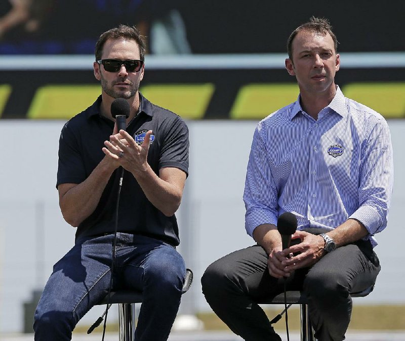 Driver Jimmie Johnson, left, speaks to the media as crew chief Chad Knaus, right, listens during a news conference for the NASCAR Sprint Cup series All-Star auto race at Charlotte Motor Speedway in Concord, N.C., Tuesday, May 5, 2015. 