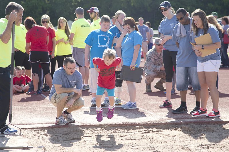 Spectators watch as Shelby Stewart, center, participates in the long-jump competition in the young athletes portion of the Area 5 Special Olympics, held at Cabot High School on April 30.