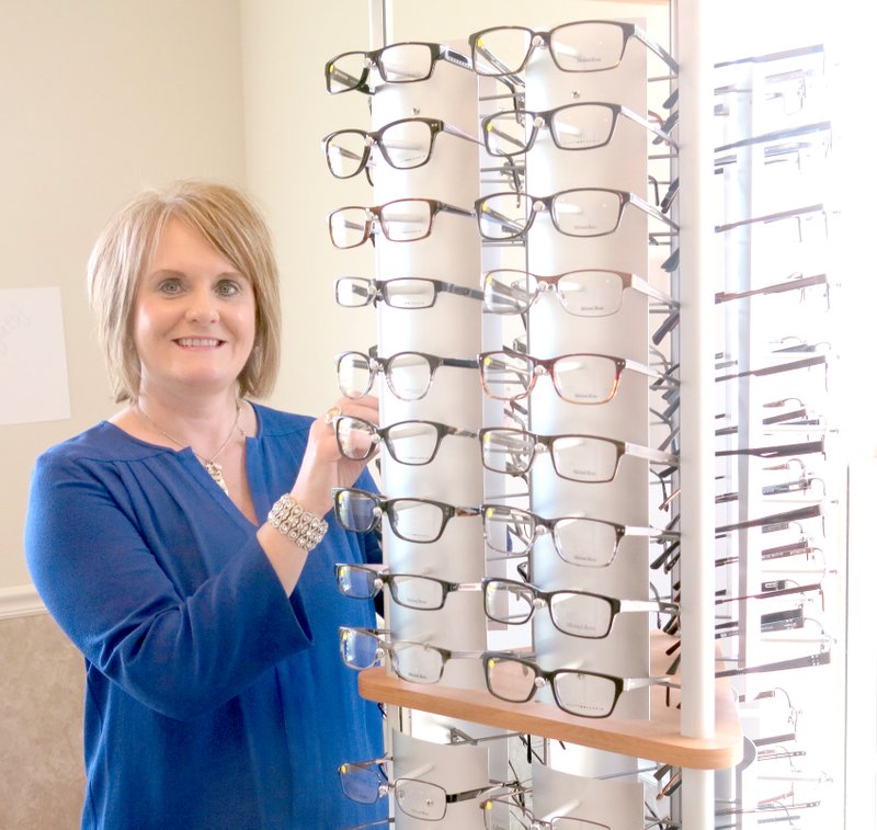 Photo by Susan Holland Reta Wilkins, office manager for the new Roberts-Philpott Eye Clinic, shows some of the many styles of men&#8217;s eyeglass frames available at the new Gravette clinic. Wilkins, of Decatur, is a former Gravette resident and is also office manager for the firm&#8217;s eye clinic in Siloam Springs.