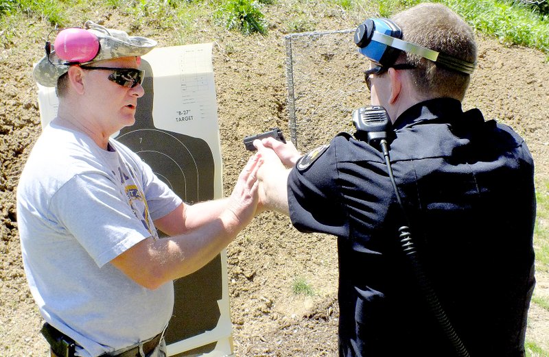 The Weekly Vista/ Brandon Howard Taking a hands-on approach, Sgt. Eric Palmer instructs Officer Robert Warren on a better two-handed shooting technique after Warren complete his on-duty weapon qualification session.