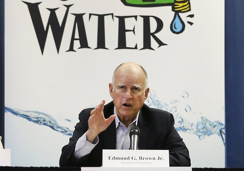 In this April 16, 2015 file photo, California Gov. Jerry Brown talks with reporters after a meeting about the drought at his Capitol office in Sacramento, Calif. The State Water Resources Control Board is considering sweeping mandatory emergency regulations to protect water supplies as water levels as some of California's lakes and reservoirs continue to decline. Brown has argued that the voluntary targets in place since early 2014 were insufficient and that Californians needed a jolt to take conservation seriously. 