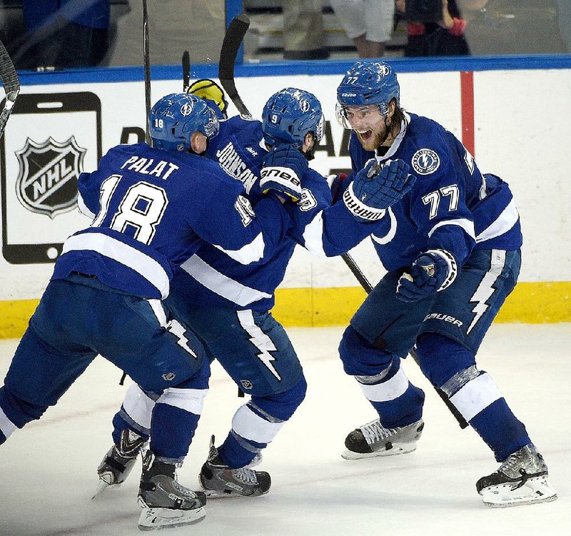 Tyler Johnson (center) of the Tampa Bay Lightning celebrates with teammates Victor Hedman (77) and Ondrej Palat after scoring the go-ahead goal with 1.1 seconds remaining against the Montreal Canadiens on Wednesday night.