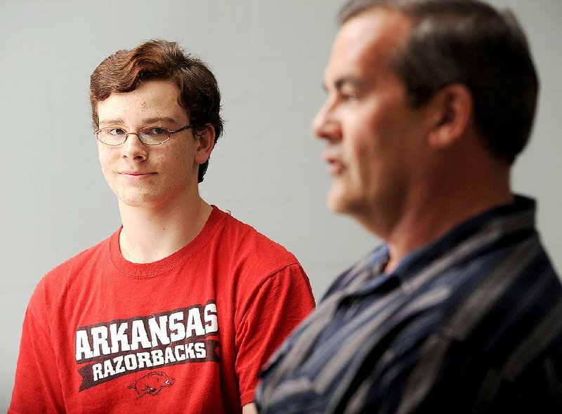 Peter Reed of Fayetteville, left, listens as his father Justin, speaks Wednesday, Feb. 29, 2012. 