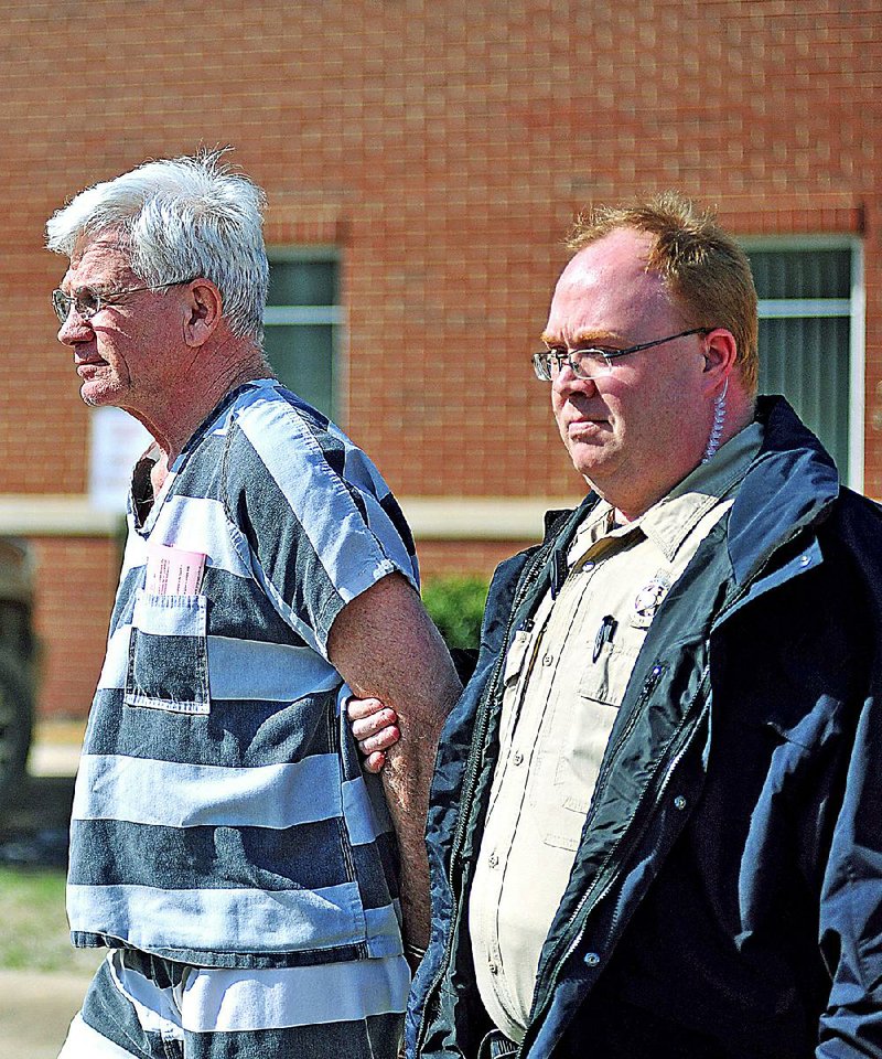 Dr. Paul Becton, left, an obstetrician-gynocologist, of Paragould, Ark., is escorted by a Greene County Sheriff's deputy on Thursday, April 17, 2014, after a probable cause hearing at the Greene County Courthouse in Paragould, Ark. 