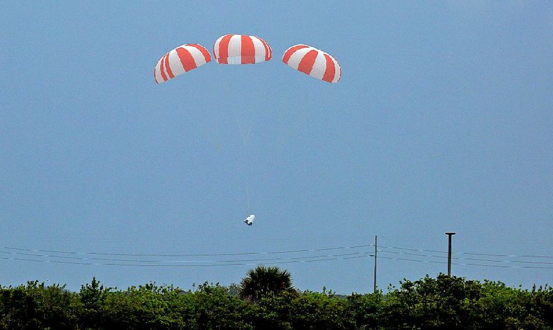 Parachutes deploy Wednesday and slow the descent of a SpaceX Dragon mock-up capsule during a test of a launch-escape system in Cape Canaveral, Fla. 