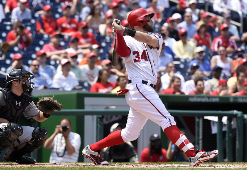 Washington Nationals right fielder Bryce Harper (34) watches the ball after hitting a home run as Miami Marlins catcher J.T. Realmuto, left, watches during the second inning of their baseball game at Nationals Park in Washington, Wednesday, May 6, 2015.