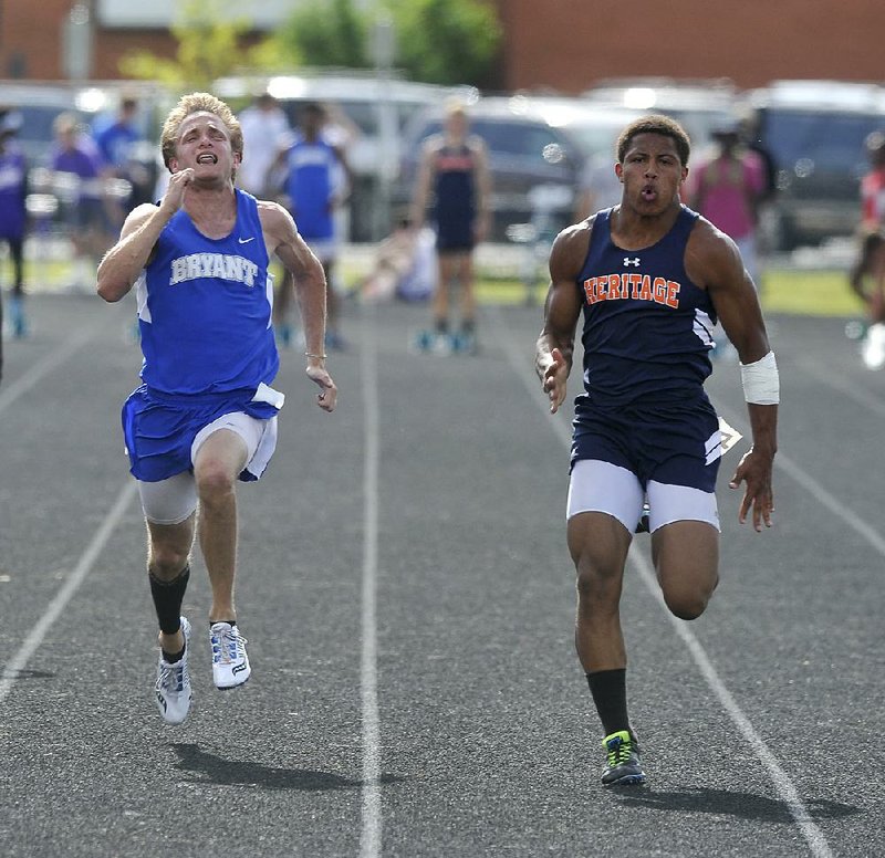 Rogers Heritage sprinter Joey Saucier (right) edges past Bryant’s John Winn to win the boys’ 100 meters Thursday at the Class 7A state championship meet in Fayetteville. Saucier finished with a time of 10.88 seconds and Winn finished in 10.97.
