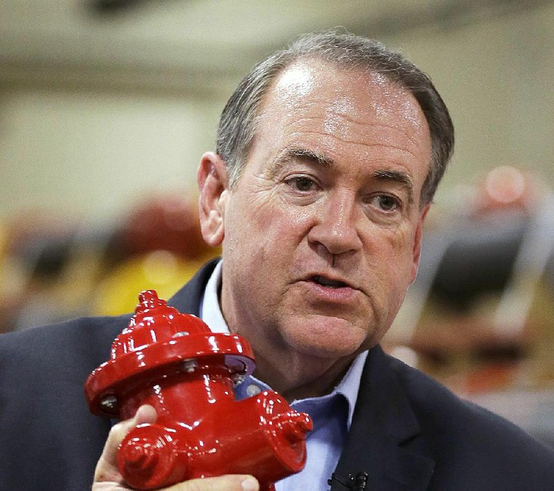 Mike Huckabee holds a miniature fire hydrant that was presented to him Wednesday during a campaign stop at the Clow Valve plant in Oskaloosa, Iowa. 