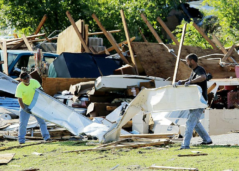People clear debris Thursday at a storage facility in storm-battered Oklahoma City. 
