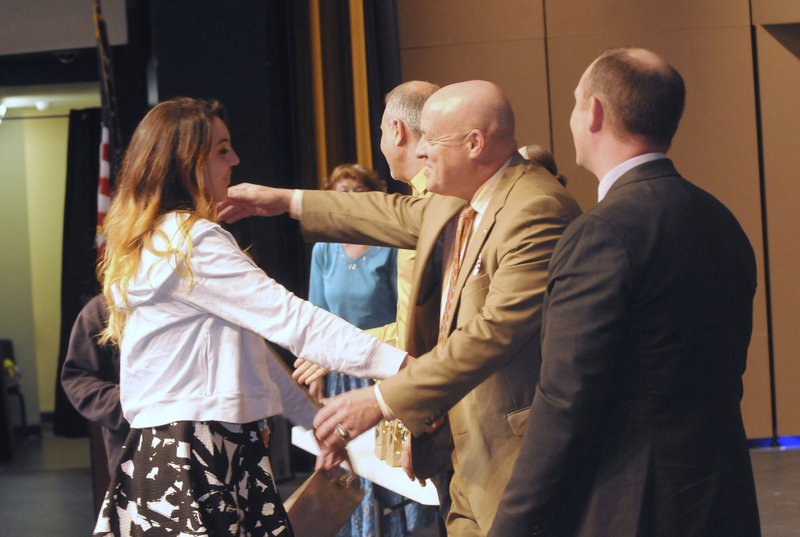 NWA Democrat-Gazette/FLIP PUTTHOFF Taylor June (left) is congratulated by Mike Poore, Bentonville school superintendent, on Thursday during the Gateway graduation at Arend Arts Center on the Bentonville High School campus. For photo galleries, go to nwadg.com/photos.