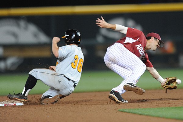 Shortstop Brett McAfee of Arkansas misplays the ball as Jared Pruett of Tennessee takes second base Friday, May 8, 2015, during the eighth inning at Baum Stadium in Fayetteville.