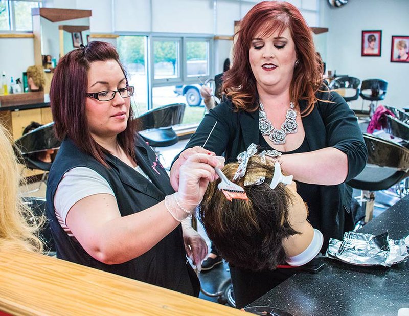 Kerri Richards, left, gets some assistance from cosmetology coordinator Wendy Sullivan at the College of the Ouachitas in Malvern. The COTO cosmetology program was recently recognized as the 2015 CHI — Cationic Hydration Interlink Technology — Partner School of the Year, an award doled out by Farouk Systems for schools that utilize the ammonia-free line of CHI products with students enrolled in their cosmetology programs.