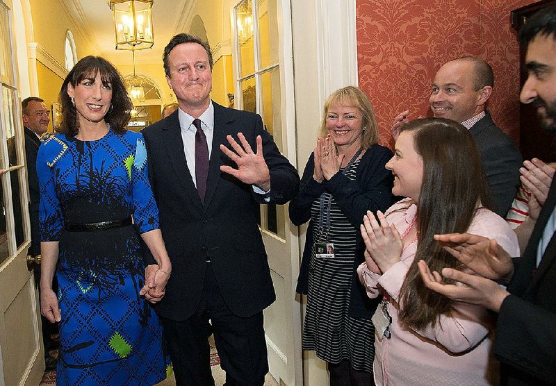 Britain's Prime Minister David Cameron and his wife Samantha are applauded by staff upon entering 10 Downing Street in London Friday May 8 2015, as he begins his second term as Prime Minister following the Conservative Party's win in Thursday's General Election . (Stefan Rousseau/Pool Photo via AP)