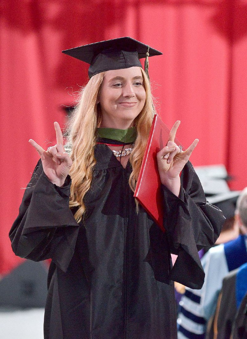NWA Democrat-Gazette/BEN GOFF -- 05/09/15 Audrey Willingham walks back to her seat after receiving her diploma during the University of Arkansas All University Commencement Ceremony in Bud Walton Arena in Fayetteville on Saturday May 9, 2015. 