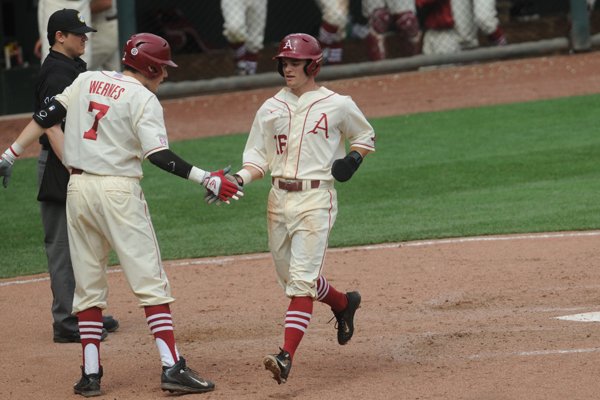 Andrew Benintendi is congratulated by Bobby Wernes after scoring a run in Arkansas' 5-2 win over Tennessee Sunday, May 10, 2015, at Baum Stadium.