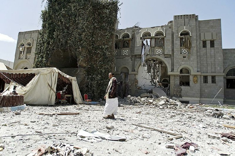 A man loyal to former Yemeni President Ali Abdullah Saleh stands guard Sunday at Saleh’s house, which was destroyed by an airstrike in Sanaa, Yemen. 