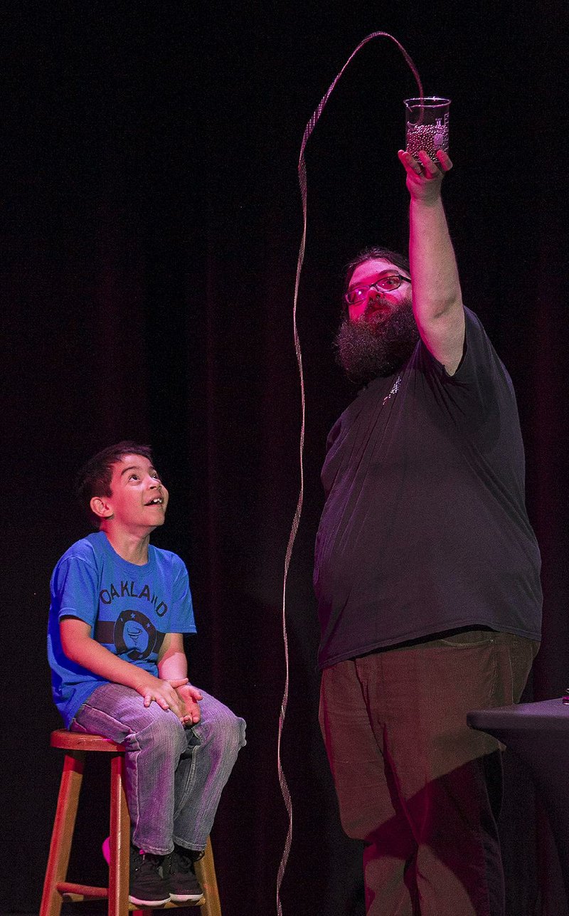 Jevonte Escamilla of Russellville watches metal beads leaping from a jar as Museum of Discovery scientist Kevin Delaney demonstrates the polymer effect. Museum officials believe Delaney’s television appearances are one reason the museum has had more visitors than expected. 