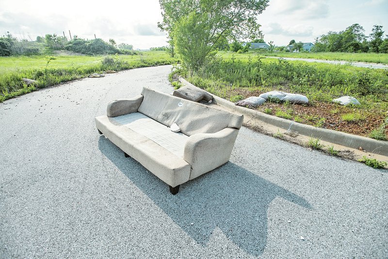 NWA Democrat-Gazette/ANTHONY REYES &#8226; @NWATONYR A couch is seen Friday along with other abandoned garbage in a vacant subdivision off First Street just south of New Hope Road. Housing development is picking up in Rogers and could possibly surpass building in years prior to the housing bubble burst of 2007. For photo galleries, go to nwadg.com/photos.