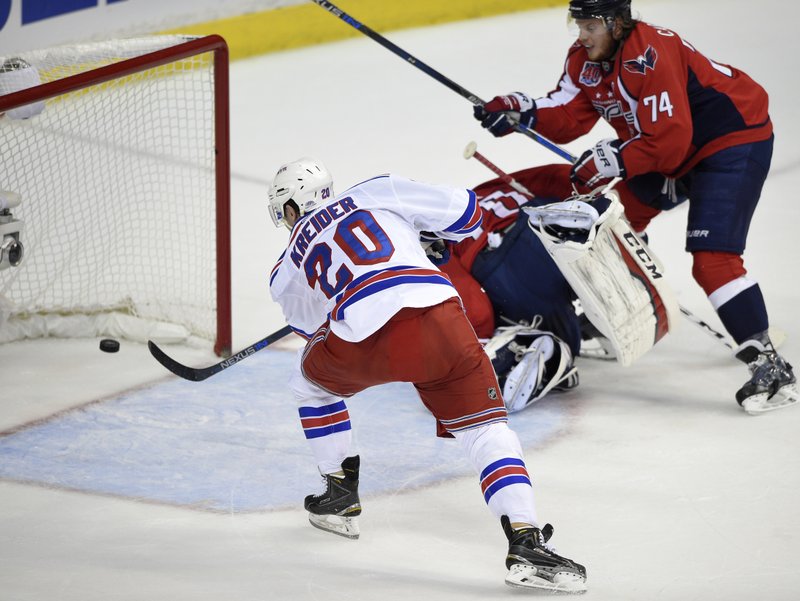 New York Rangers left wing Chris Kreider (20) scores his second goal of the period during the first period past Washington Capitals goalie Braden Holtby (70), center, and John Carlson (74) in Game 6 in the second round of the NHL Stanley Cup hockey playoffs, Sunday, May 10, 2015, in Washington.