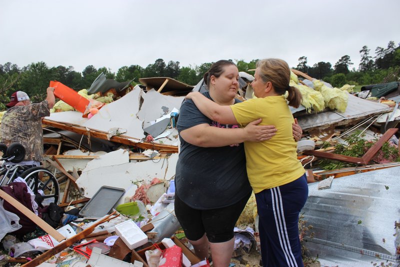 Tracy Mays, right, hugs Kimmie Godwin as the two look for items to salvage in the wreckage of Godwin's mother's destroyed mobile home in Nashville.