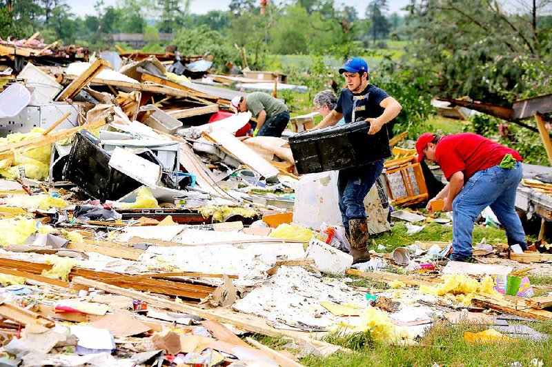 Michael Bevill salvages a black trunk from the wreckage of his aunt’s home Monday at the D&J Trailer Park in Nashville, where two people died in a tornado late Sunday night. 