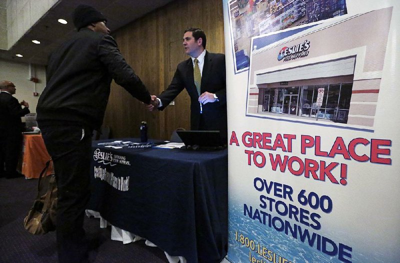 A representative of a swimming pool supply company greets a job seeker last month at a career fair in Chicago. 