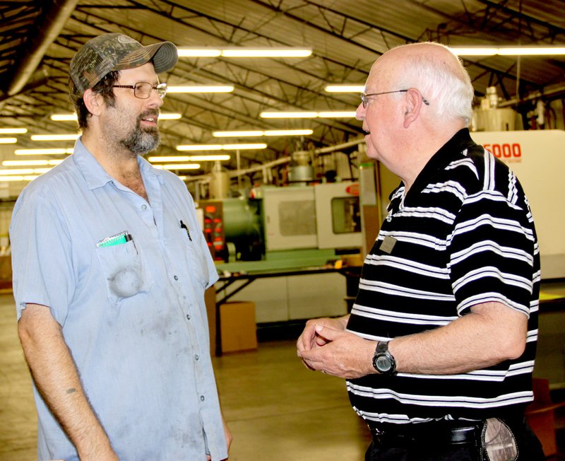 Jack English with Marketplace Chaplains USA, right, visits with Steven King of Lincoln in the plant area at Polytech Plastic Molding in Prairie Grove.