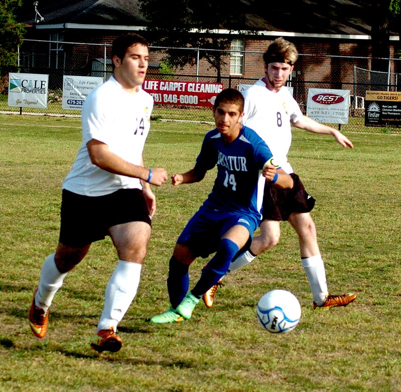 Photo by Mike Eckels Bulldog captain Eddie Lucio (#14) slips past two Prairie Grove players to intercept the ball during the Decatur-Prairie Grove soccer match at Tiger Stadium May 5. Decatur took the match, 7 to 1.