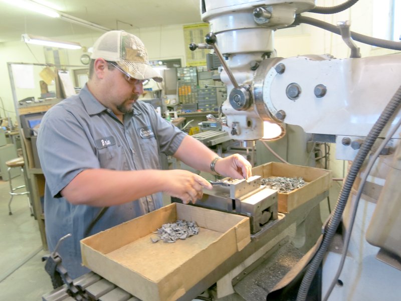 Photo by Susan Holland Bryan Carrier, of Gravette, is busy at his workstation turning out a boxful of custom pistol parts. Graco&#8217;s first product was a handgun clip for competition shooters, but the company has expanded to produce a variety of custom parts.