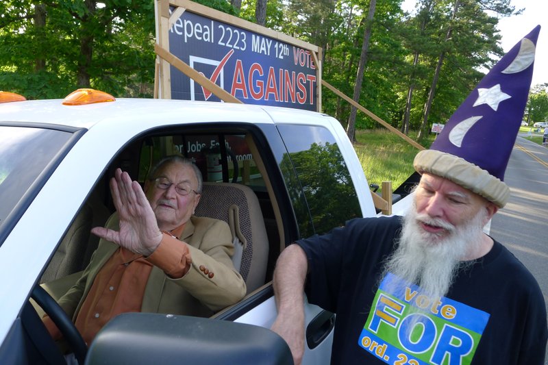 Rene' J. Chouinard, left, and Christopher Young have an intense but amicable conversation on Tuesday near a polling place in Eureka Springs. Residents were voting Tuesday to decide whether to keep the city's anti-discrimination ordinance. Young, 69, was arguing in favor of the ordinance. Chouinard, 88, was arguing for repeal and carried a sign saying so in the bed of his pickup truck. Young said he wears his wizard's hat to help diffuse tense gatherings in the tourist town. 