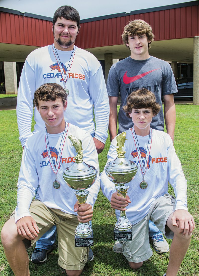 In the front row, Will Carpenter, left, and his teammate, C.J. Brustrom, hold the trophies they received as first-place winners in the 2015 Arkansas State High School Fishing Championship. In the back row are Layton Lovell, left, and his teammate, Jordan Bumpous, who won fourth place in the tournament.
