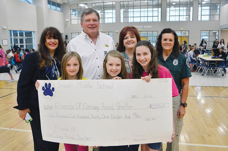 Raymond and Phyllis Simon Middle School sixth-graders, front row, from left, Lily Butler, Emma Page and Elise McGarrity donate $1,531.68 to Friends of the Conway Animal Shelter. Also pictured are, back row, Donna Adolph, gifted and talented specialist at the school; Tom DeBlack, a member of the Friends board of directors; Chris Quinn, president of the board; and Shona Osborne, director of the Conway Animal Welfare Unit.