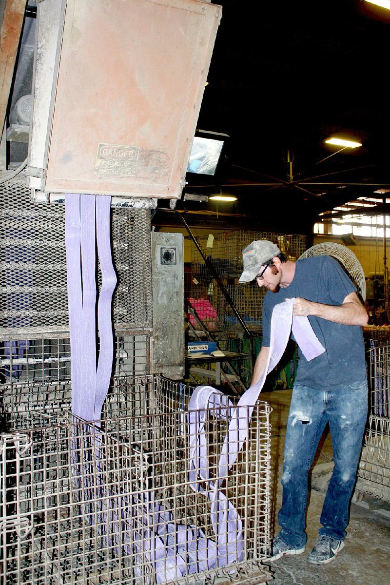 David Walters prepares rubber strips for the extruder at Alliance Rubber Co. in Hot Springs. He is one of nearly 180 employees at the family-owned-and-operated company. 
