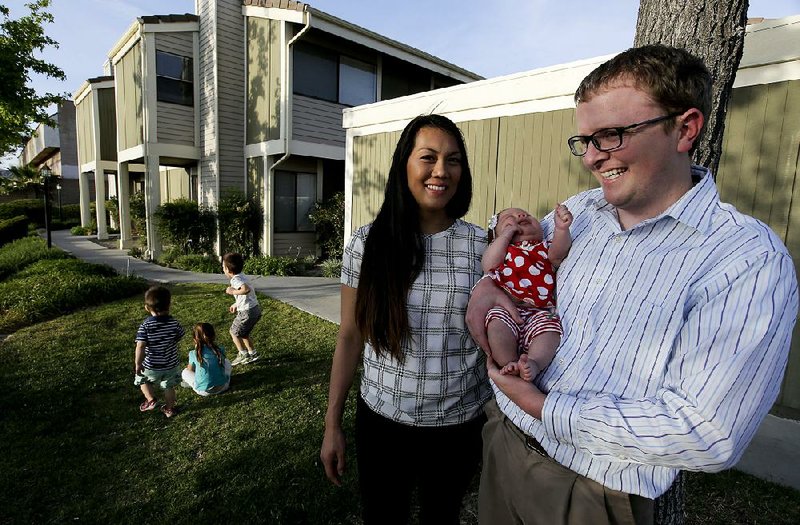Brett Singley (right) stands with his wife, Angelynn, and their children Ben, Isla, Aria and Isaiah in front of their townhome in Santa Clarita, Calif. 