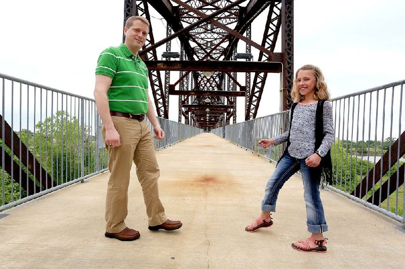 Volunteers Chris Olson and Emma Grace Bles set foot on the bridge at the Clinton Presidential Center in Little Rock. They will be among the participants in the Take Steps for Crohn’s and Colitis Walk May 30 on the bridge and the lawn outside the center.