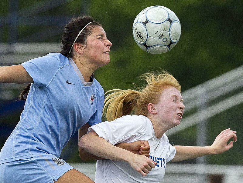 Fort Smith Southside’s Nancy Mendoza (left) and Bryant’s Caroline Campbell leap for a header during Friday’s game in the Class 7A girls soccer state tournament at Bryant. 