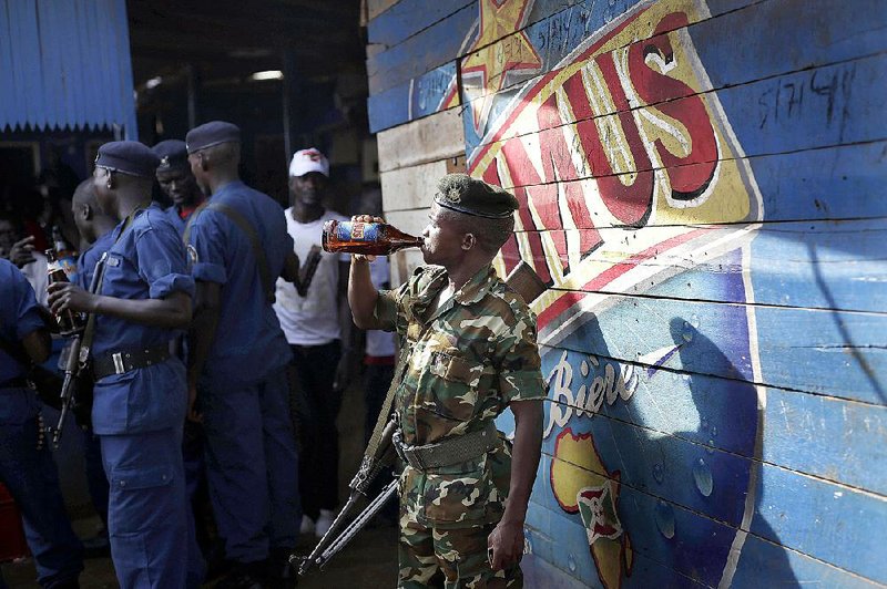 A Burundi soldier joins police officers Friday celebrating President Pierre Nkurunziza’s return in the streets of the capital, Bujumbura. 