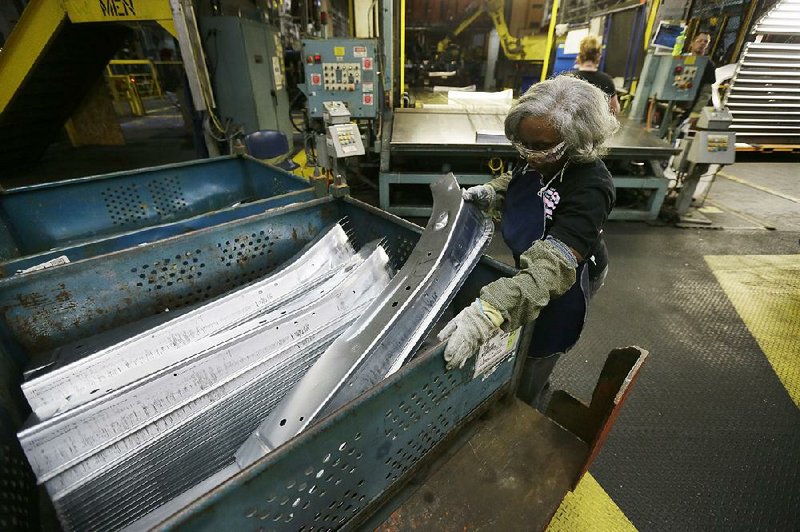 Line worker Vanassa Stafford loads a bin with stamped parts at the General Motors Pontiac Metal Center in Pontiac, Mich., last month. U.S. industrial production fell 0.3 percent in April, the Federal Reserve said Friday. 