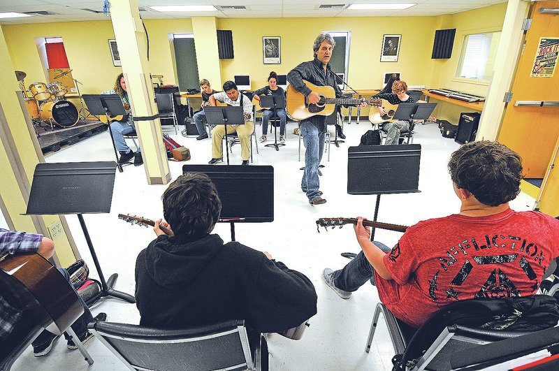NWA Democrat-Gazette/J.T. WAMPLER David Singleton, guitar teacher at the Arkansas Arts Academy, plays Thursday along with his students in Rogers. The charter school is making changes in preparation for next school year, including replacing about 20 percent of its staff. For photo galleries, go to nwadg.com/photos.