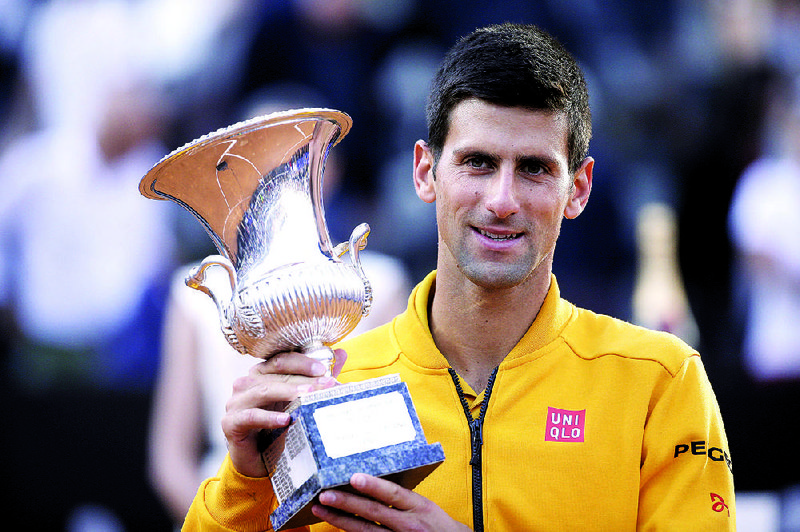 Serbia's Novak Djokovic poses the cup he received after winning the final match at the Italian Open tennis tournament, in Rome, Sunday, May 17, 2015. 