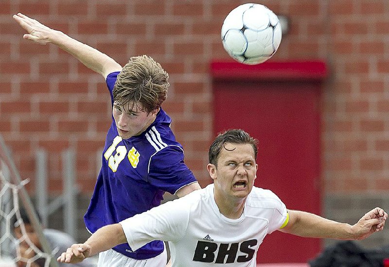 Bentonville’s Josh Howard (right) and Justin Blair of Little Rock Catholic leap for a header during Saturday’s semifinal game in the Class 7A boys soccer state tournament at Cabot High School’s Panther Stadium.