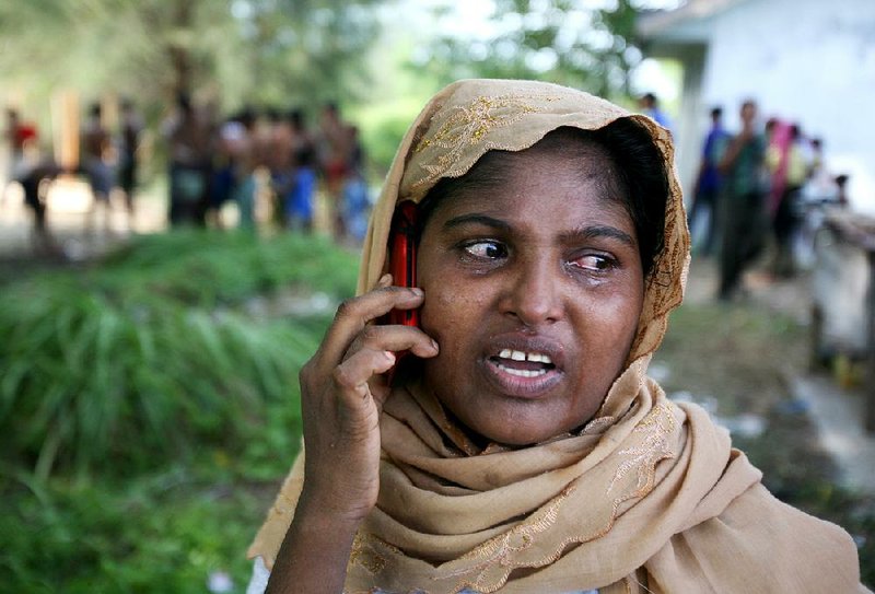 An ethnic Rohingya woman at a temporary shelter in Langsa, Aceh province, Indonesia, holds an emotional conversation Saturday with a relative back home.