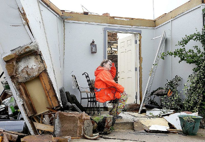 Carol Cole sits Sunday in front of her home in Broken Arrow, Okla. A strong storm hit the area Saturday night and early Sunday, destroying the home. According to the National Weather Service, tornadoes touched down Sunday near Elmer and Tipton in southwest Oklahoma. 