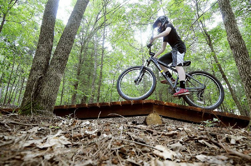 Jacob Whorton, 13, of Rogers rides along a newly constructed mountain-bike trail Thursday at Camp War Eagle in Benton County.