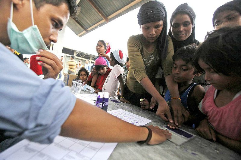 Ethnic Rohingya women and children have their fingerprints taken Sunday during registration at a temporary shelter in Langsa, Aceh province, Indonesia. 