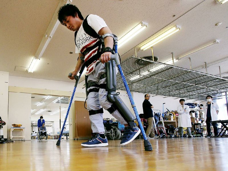 Yuichi Imahata uses a robotic exoskeleton called ReWalk at Kanagawa Rehabilitation Center in Atgugi, Japan, in April. He hopes to one day to use the device to stand and watch his daughter at sports events. 