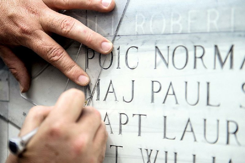 A contractor works April 21 adding names to the High Flight Memorial at Little Rock Air Force Base in Jacksonville.