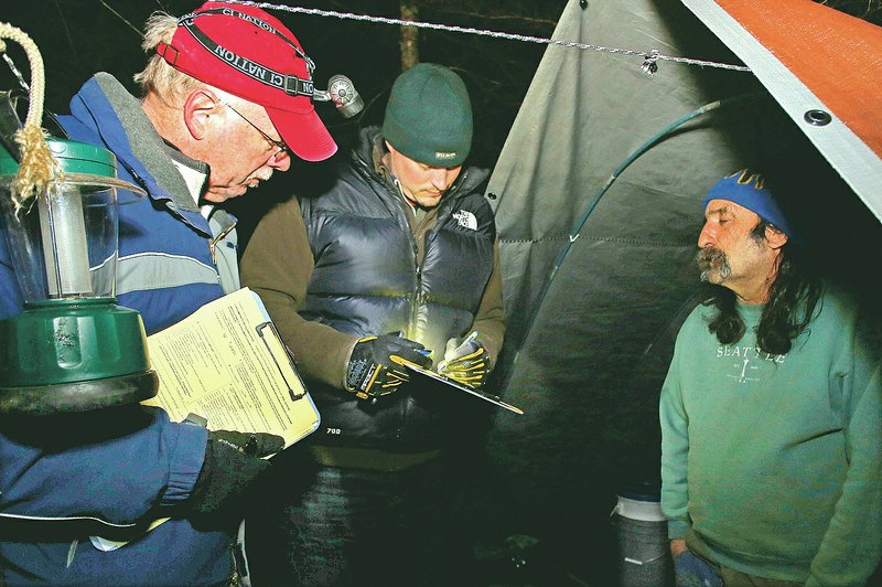 NWA Democrat-Gazette/DAVID GOTTSCHALK &#8220;Chief&#8221; (from right) answers questions Jan. 30 from Jon Woodward, chief executive officer of Seven Hills Homeless Center, and Kevin Fitzpatrick, professor of sociology and director of the University of Arkansas&#8217; Community and Family Institute, outside his tent in the woods south of Martin Luther King Jr. Boulevard in Fayetteville in the predawn hours. Chief participated in the Northwest Arkansas&#8217; biennial, 24-hour homeless census. For photo galleries, go to nwadg.com/photos.