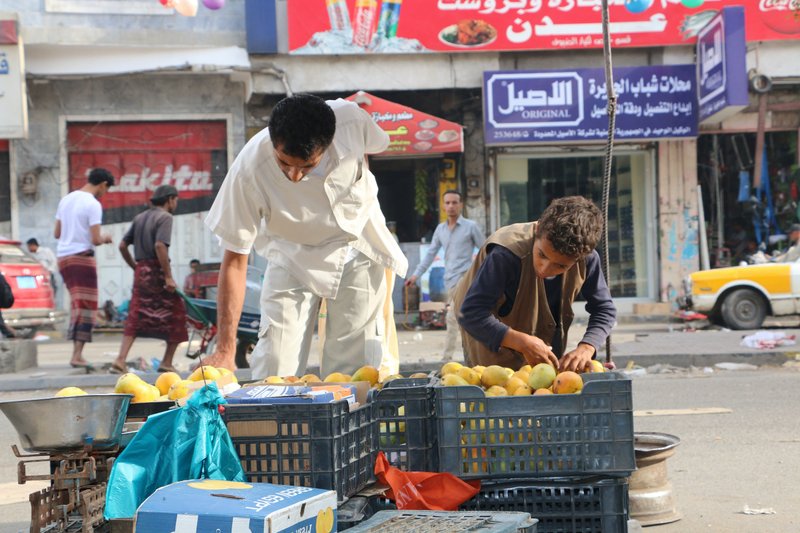 A Yemen boy, right, sells fruits on a street in Taiz city, Yemen, Sunday, May 17, 2015. Hundreds of Yemeni politicians and tribal leaders began talks Sunday in Saudi Arabia on the future of their war-torn country as a five-day humanitarian cease-fire was set to expire, though Shiite rebels there were not taking part. 